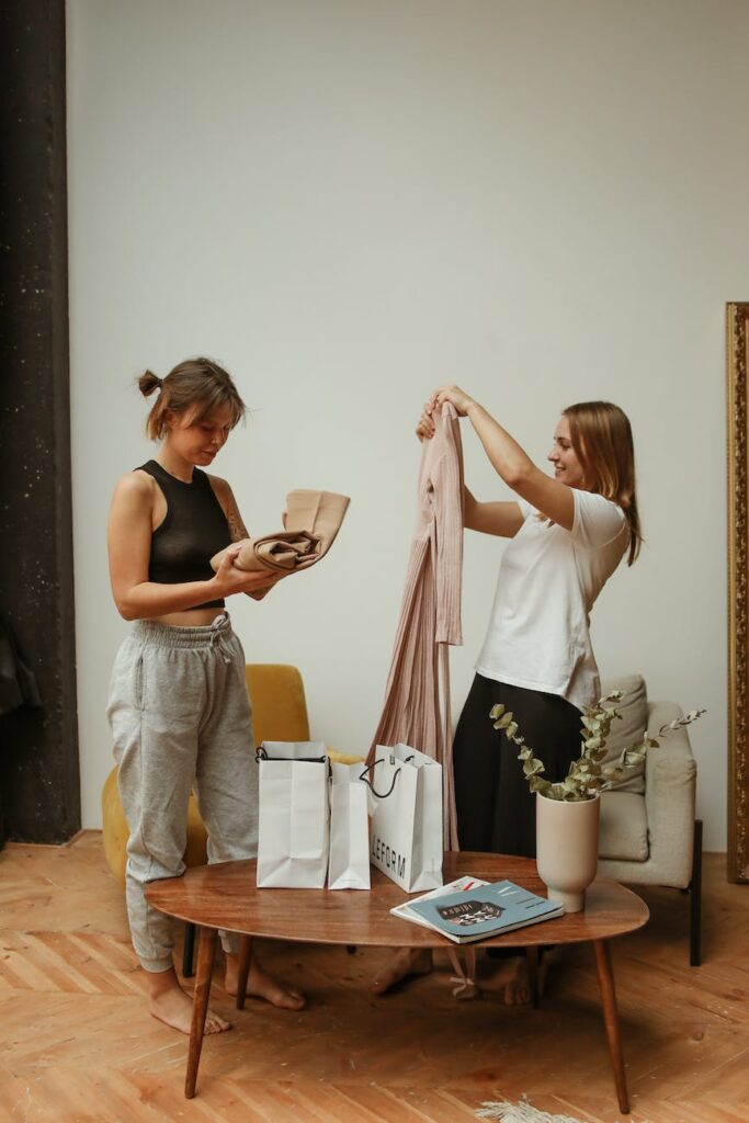 woman in white sleeveless shirt and gray pants holding brown book