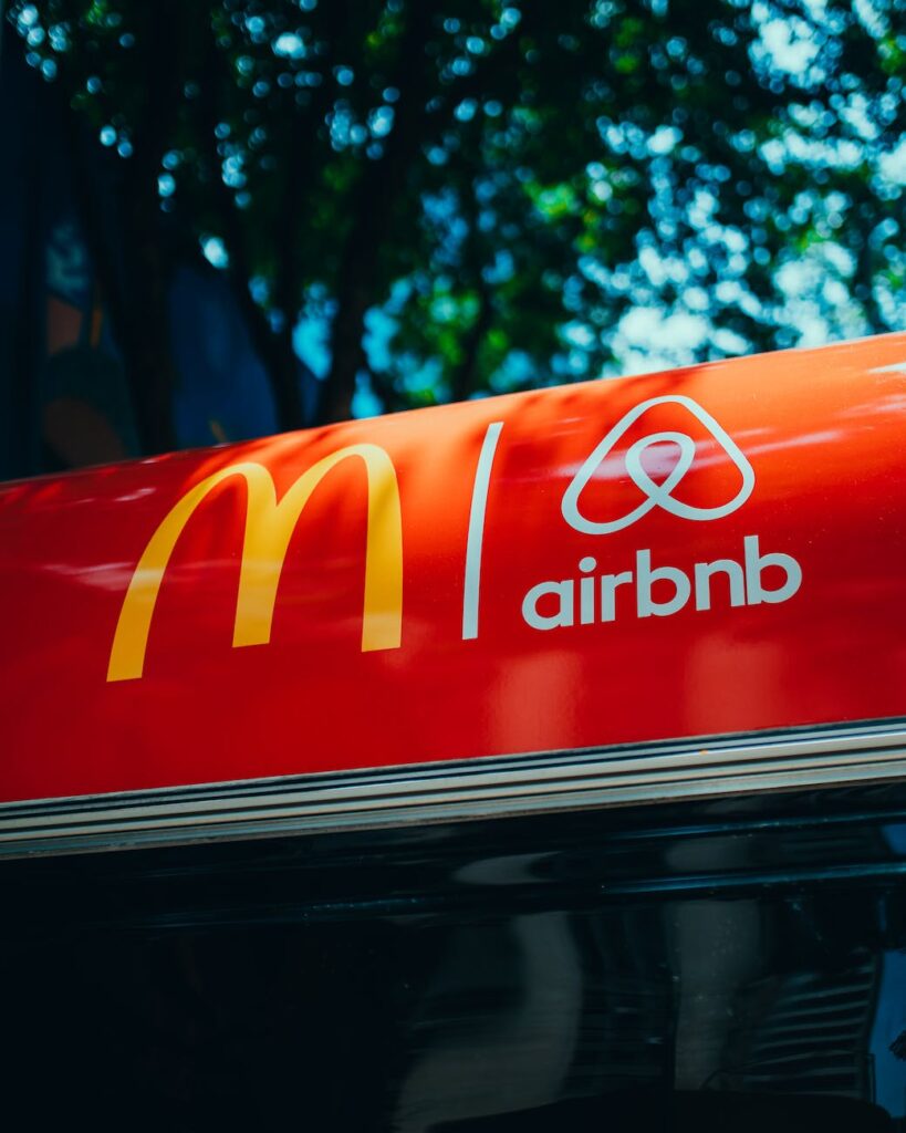 two logos on a red surface and tree in background