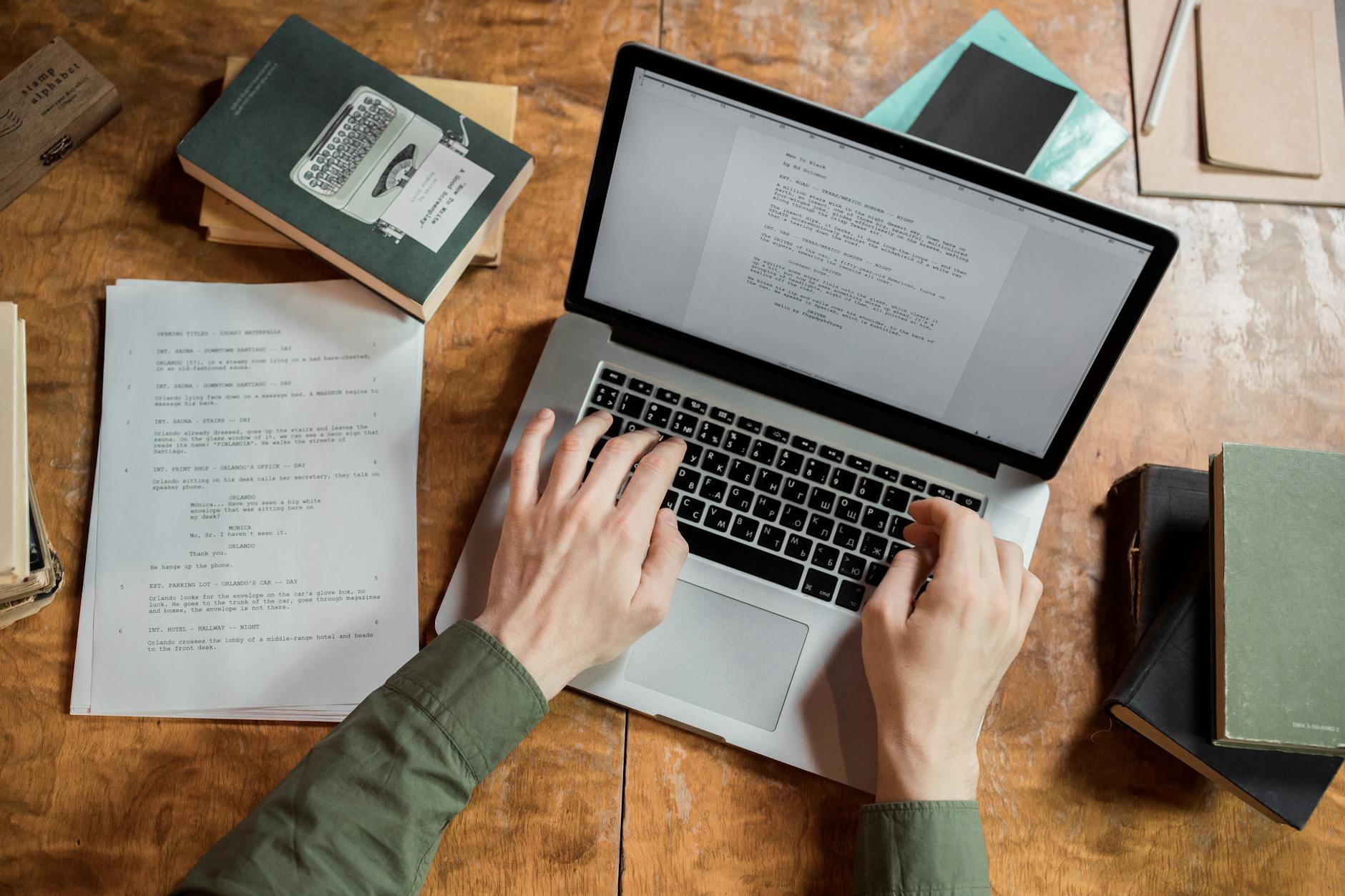person using macbook pro on brown wooden table